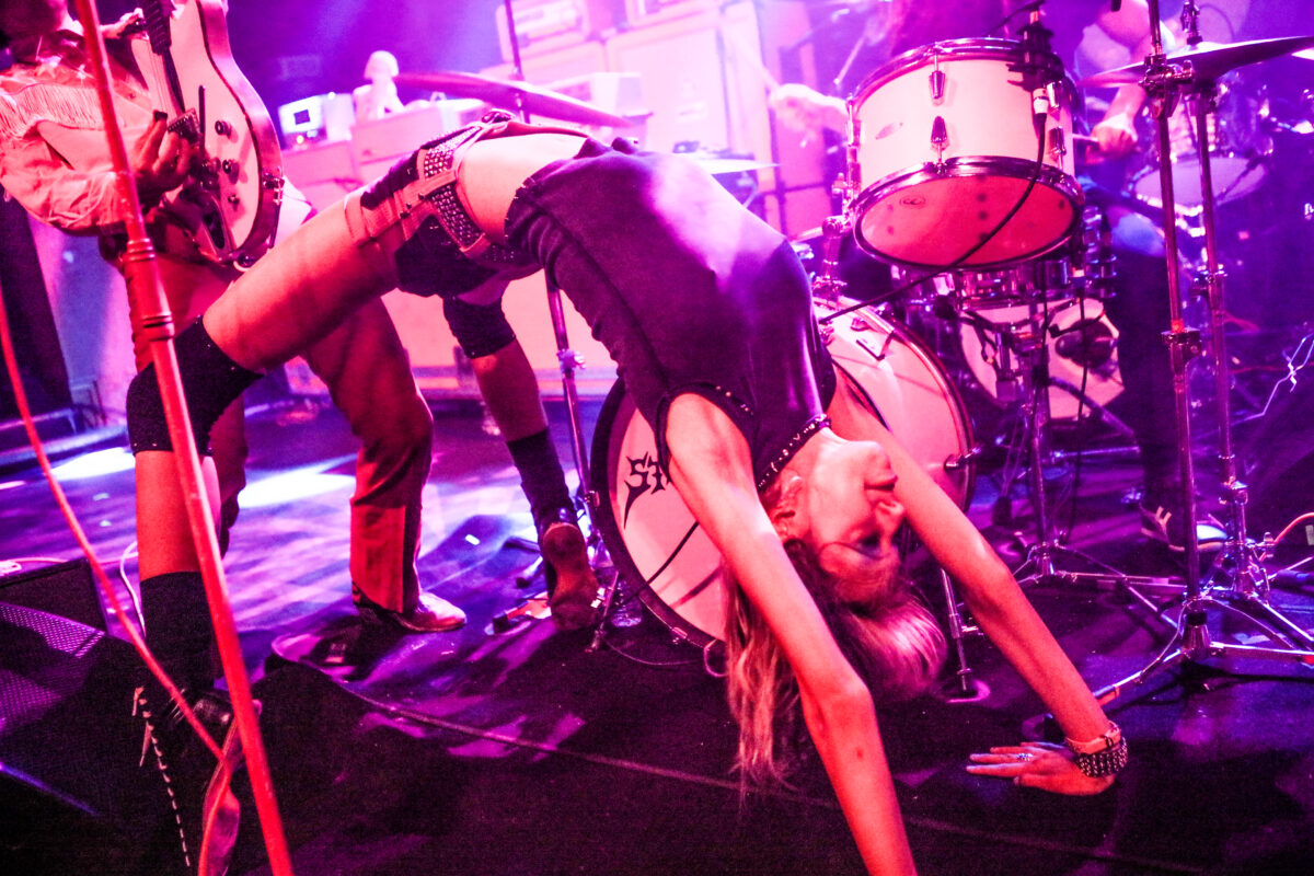 Arrow de Wilde of Starcrawler getting into a full wheel pose on stage